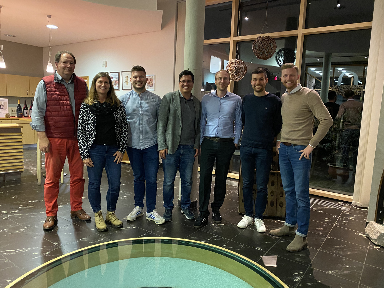 Sechs Männer und eine Frau stehen im Halbkreis im Weingut Schloss Ortenberg