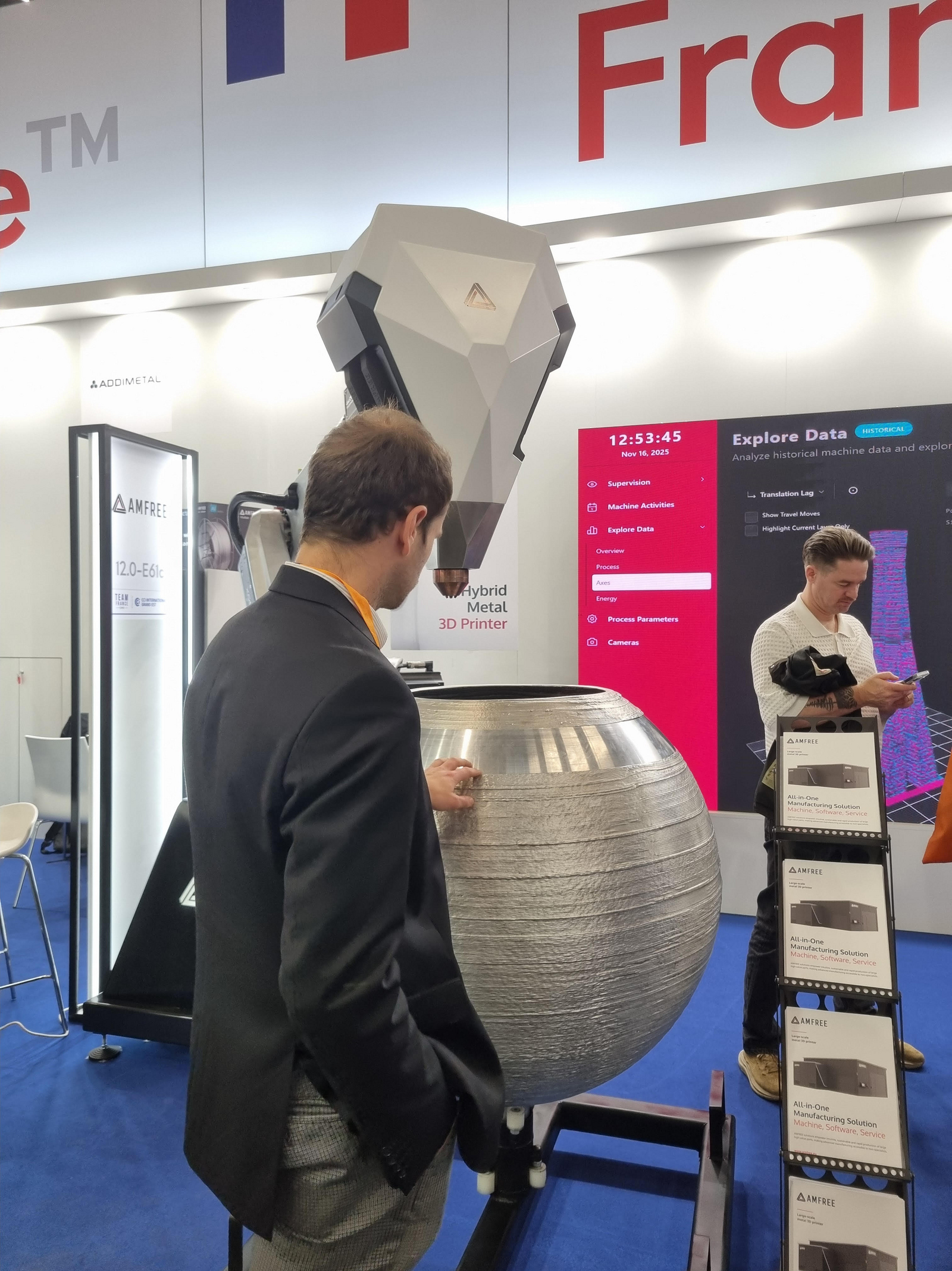 Daniel Kehret admires a large 3D-printed metal vase manufactured by a robot-assisted hybrid metal 3D printer from AMFree.