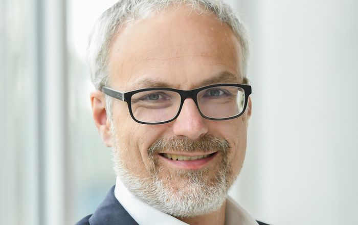 Porträt eines Manns im dunklen Anzug mit Brille