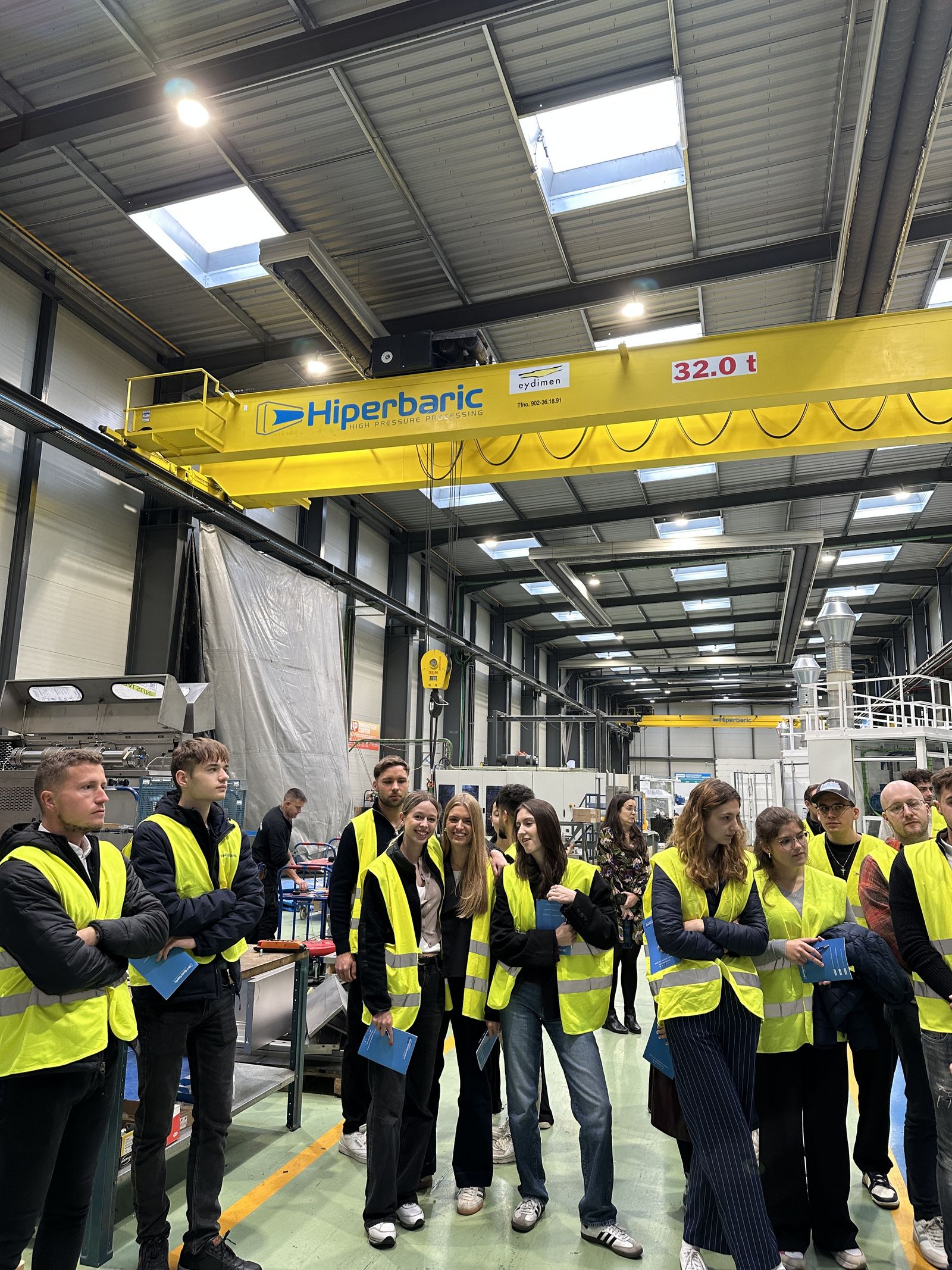 Junge Menschen in gelben Warnwesten bei einem Besuch in einem Industrieunternehmen 