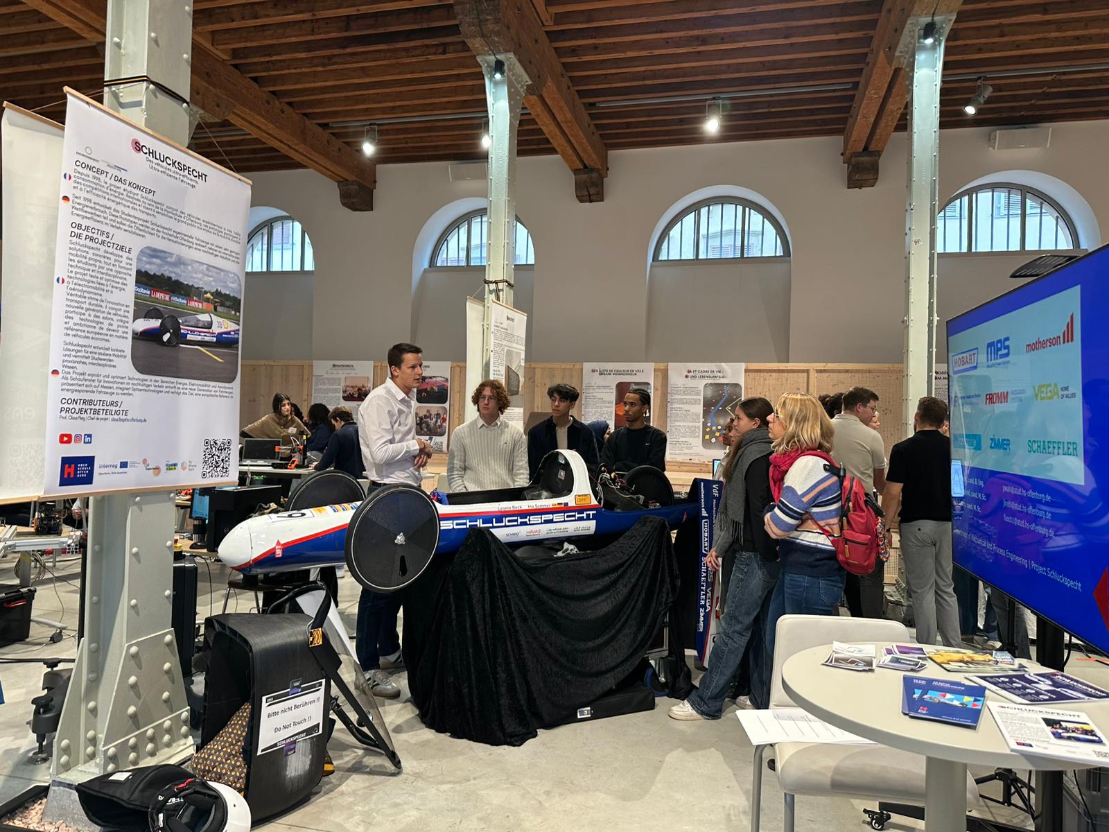 Menschen stehen um ein Rennwagen herum